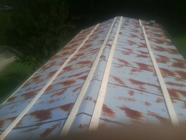 Rusted metal roof panels with new wood purlins before replacement — Storm Damage Roof Repair in Sanford by Roofing Brothers